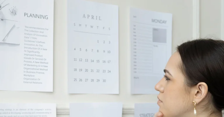 Woman studying a wall calendar, tracking her irregular periods