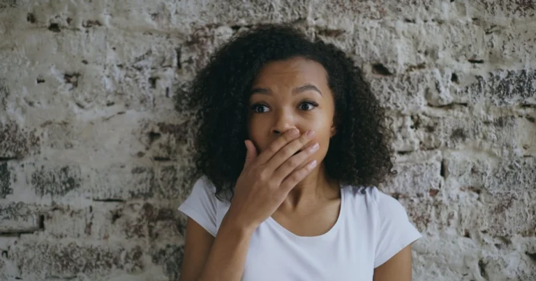 Surprised woman covering her mouth, recognizing symptoms on a checklist