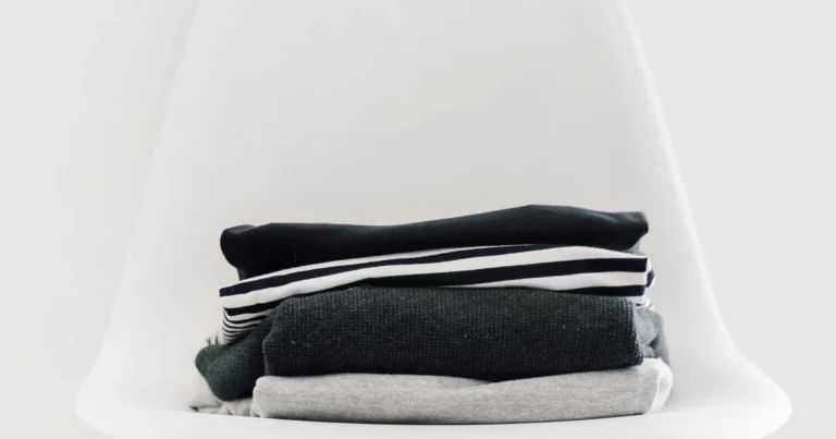 Folded tops and leggings stacked on a white chair