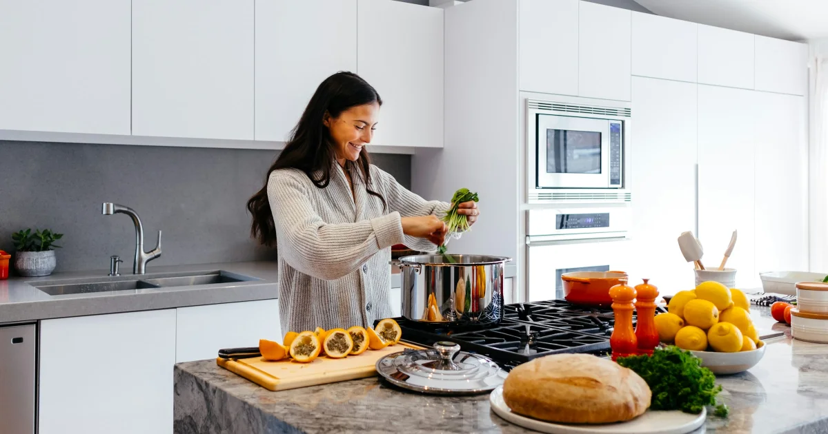 Smiling woman cooking vegetables in a bright kitchen