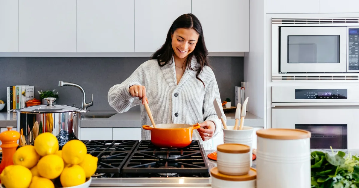 Smiling woman cooking a healthy meal in a bright kitchen