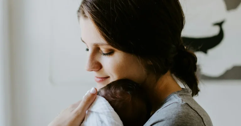 Mother holding her newborn close to her shoulder